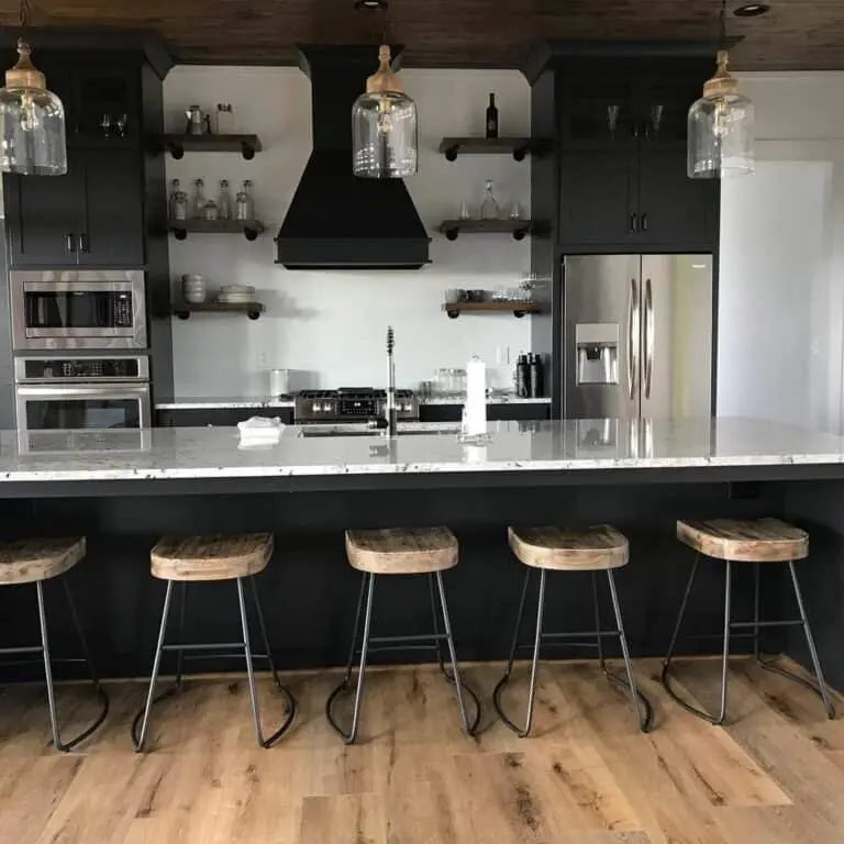 Black cabinets, marble island, wood accents