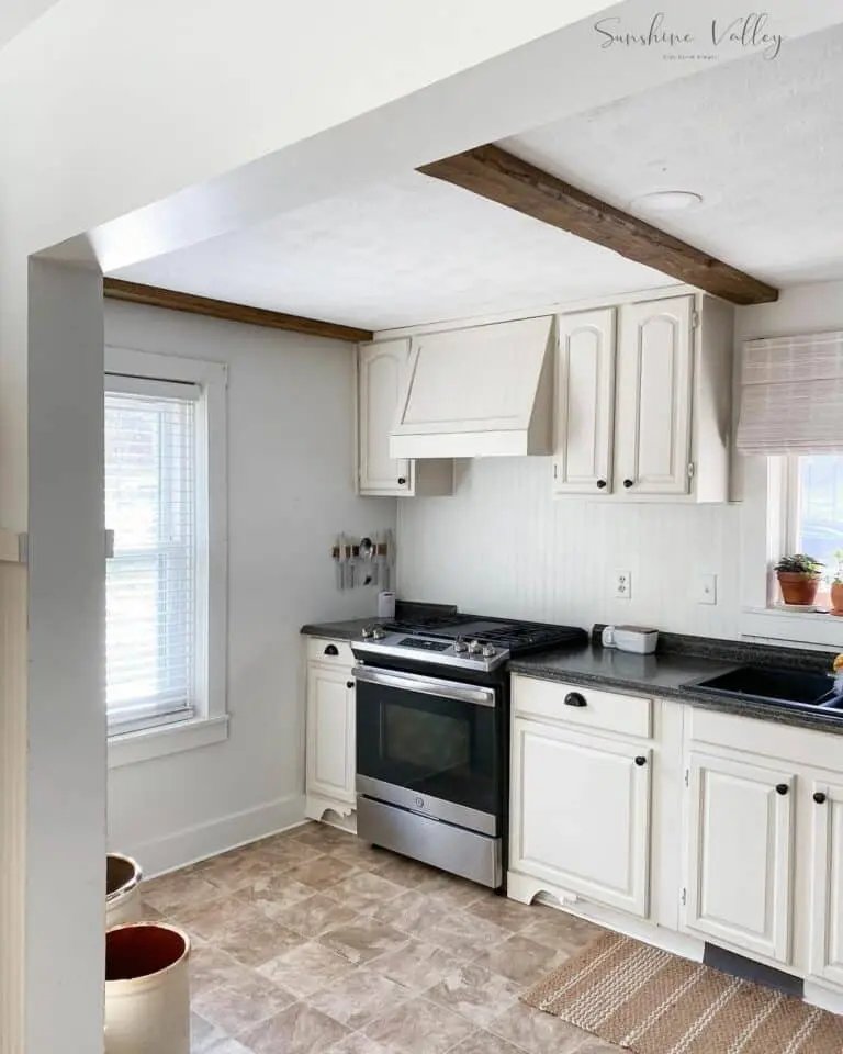 White shiplap walls
Black granite countertop
Cream cabinets